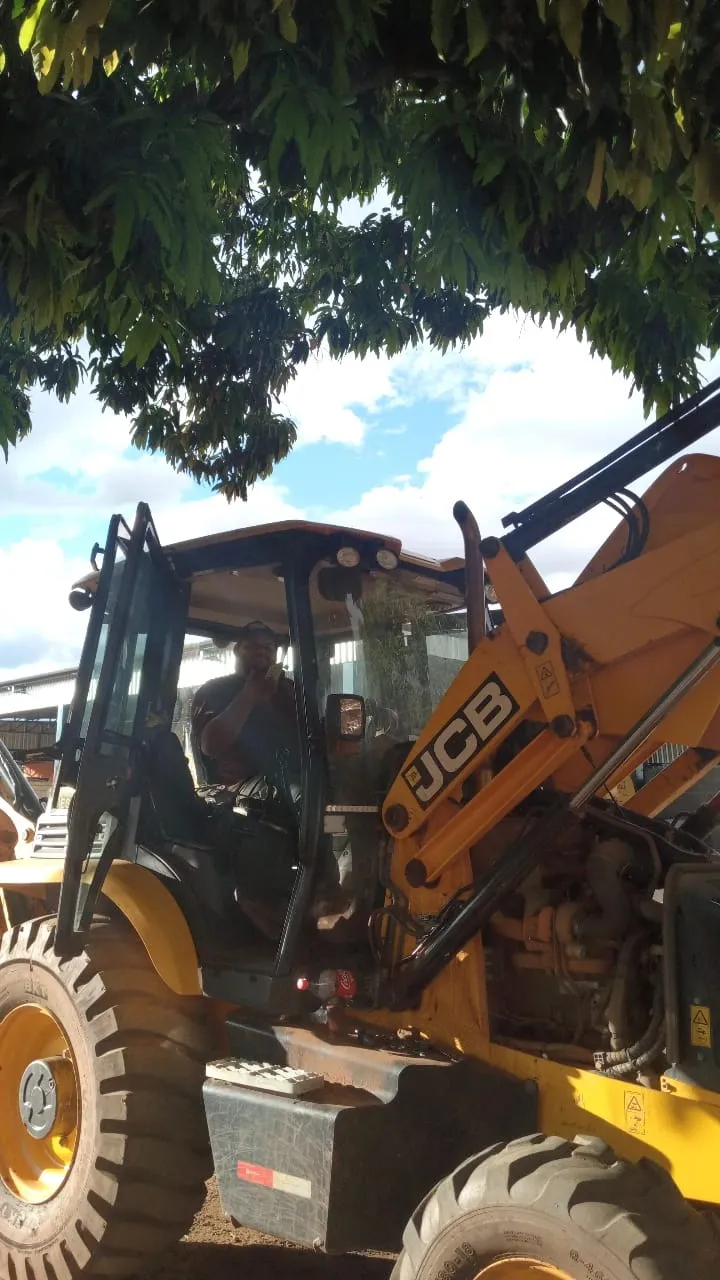 Vitão (Vitor) mecânico especialista em cima de uma retroescavadeira